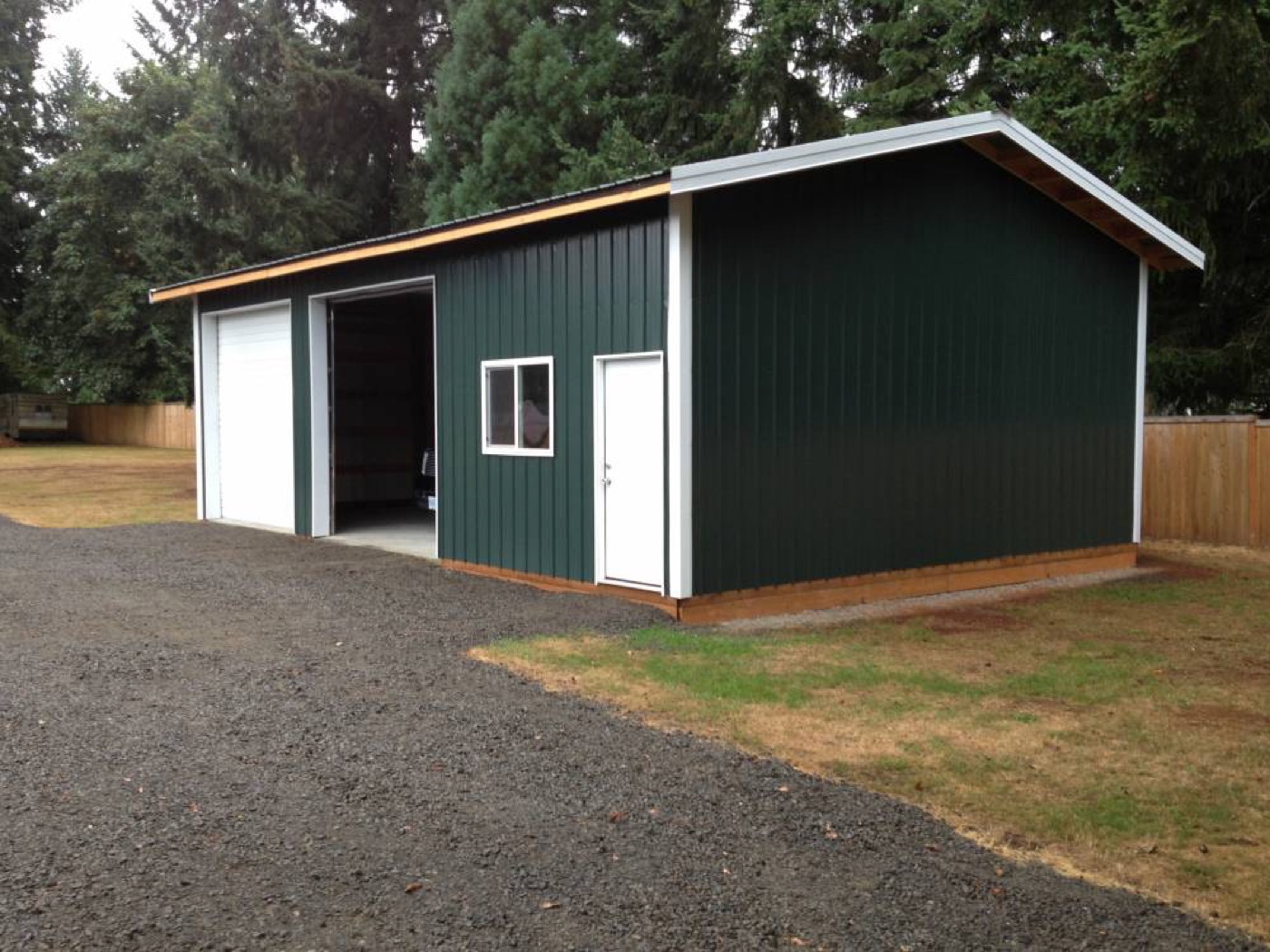 Dark green garage with white trim and tan wainscot, built by Miner Pole Buildings