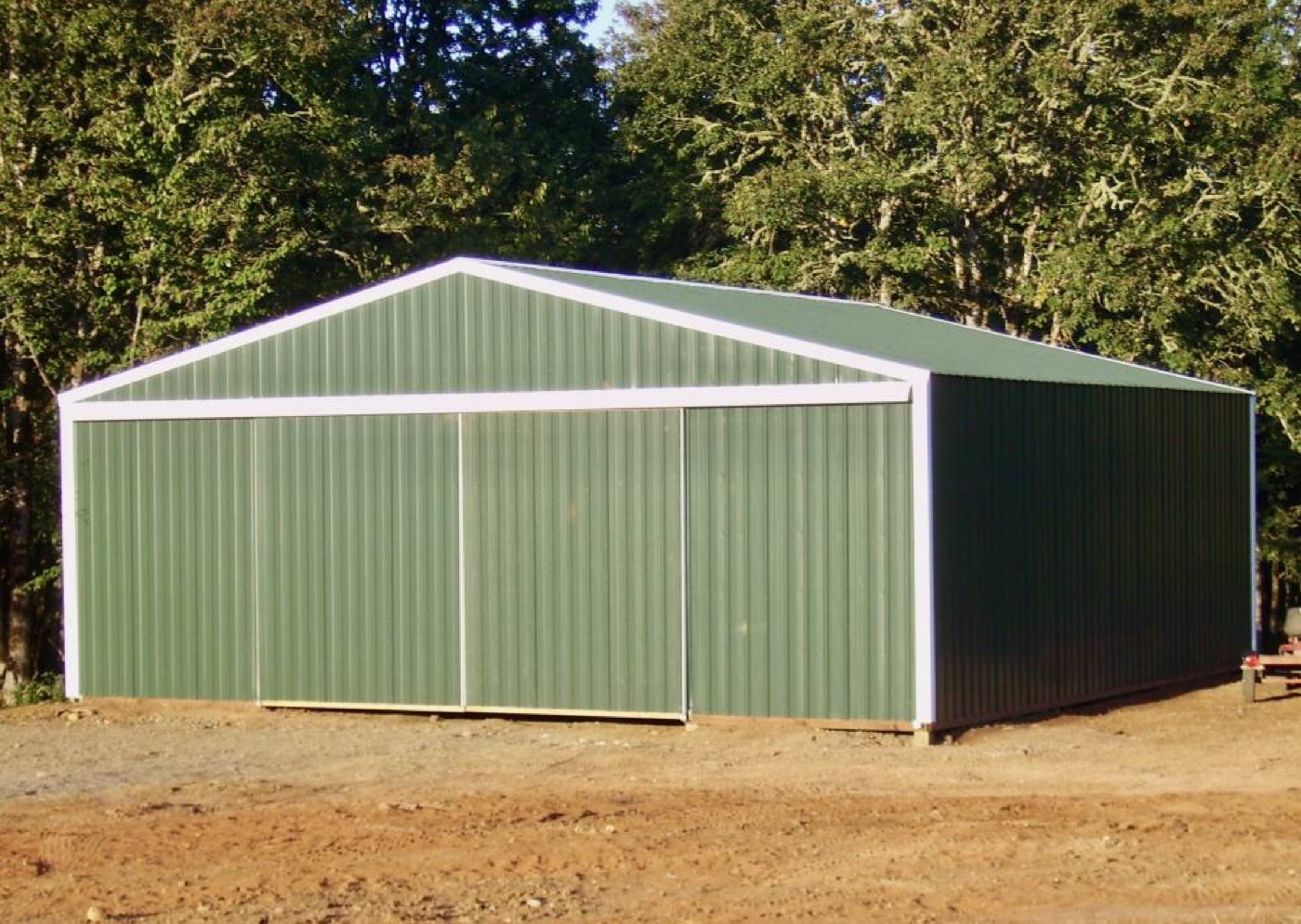 Sage-green post-frame shop with sliding doors, built by Miner Pole Buildings