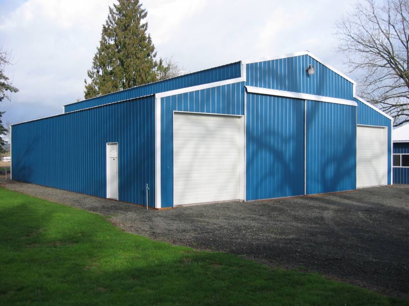 Bright blue monitor-style shop with white trim, built by Miner Pole Buildings