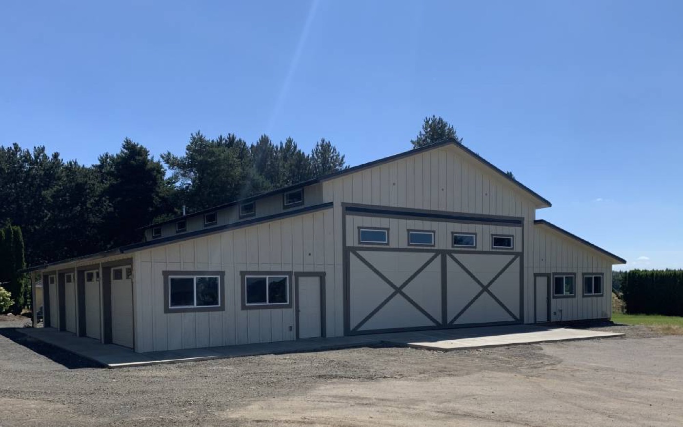 Tan monitor barn with white X-trim doors, built by Miner Pole Buildings