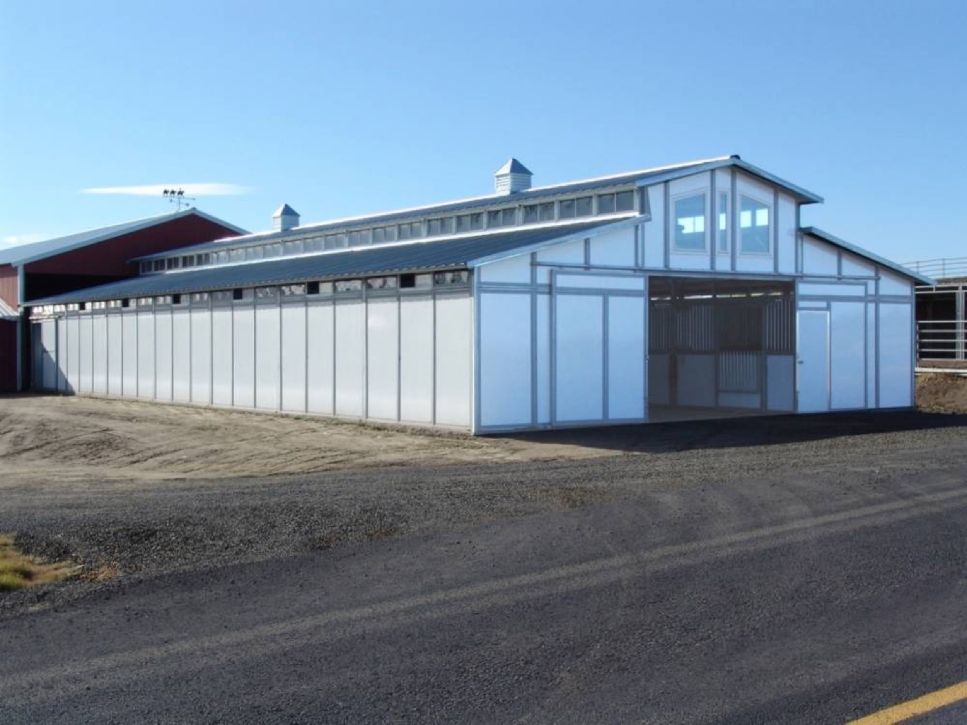White monitor barn under a blue sky, built by Miner Pole Buildings