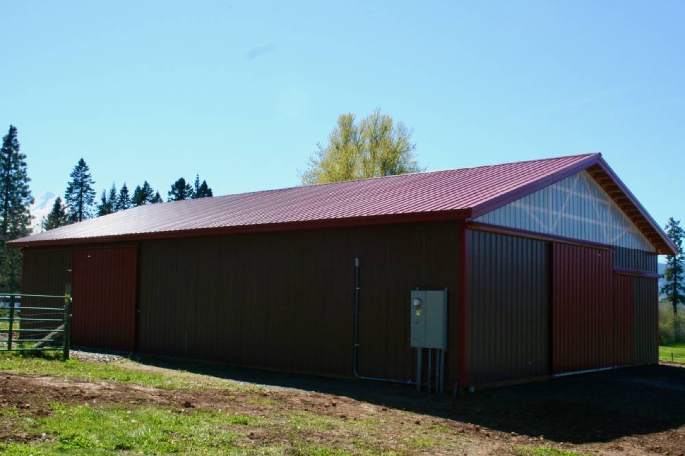 Brown barn with a red metal roof and trim, built by Miner Pole Buildings