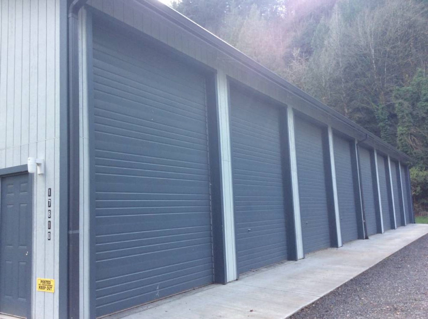 Gray multi-bay storage units with roll-up doors, built by Miner Pole Buildings